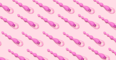 Adult sex toy pattern on pink background.