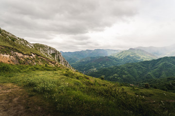 Naklejka na ściany i meble Landscape view of cloudy mountains in Asturias, Spain during summer. 
