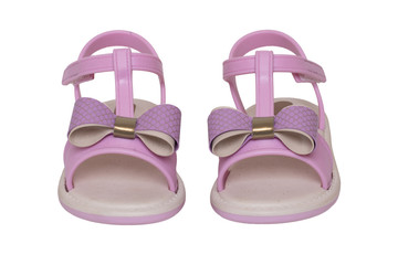 Pink sandals isolated. Close-up of cute pink sandals with a bow for the little girl isolated on a white background. Trendy summer shoe fashion for children. Macro.