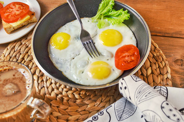Breakfast with fried eggs with lettuce ieaves,tomatoes,sandwich and coffee. Healthy lifestyle.