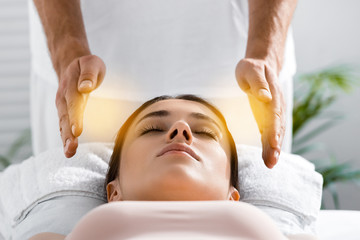 cropped view of healer standing near patient on massage table and cleaning aura - obrazy, fototapety, plakaty