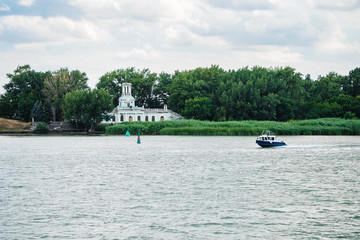 the boat floats on the Don River against the background of the old building of the Pilots' Station...