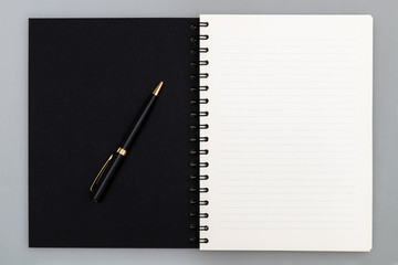 Business copy space, luxury spiral notebook with black cover and pen, top view