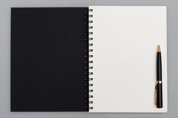 Business copy space, luxury spiral notebook with black cover and black pen, top view