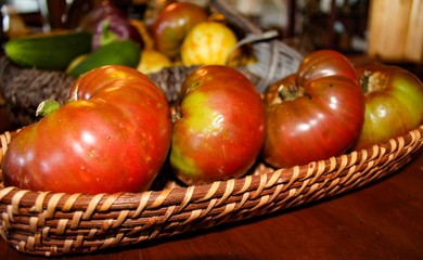Closeup of Heirloom Tomatoes on Wooden Table and basket, selective focus