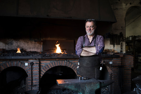 Portrait of confident blacksmith in his workshop