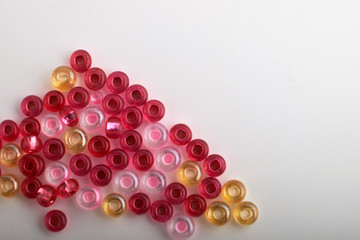 Multi-colored beads.Colorful beads on a wooden surface.It is used in finishing fashion clothes.Variety of shapes and color to make abead necklace or a string of beads toplease a woman of fashion.
