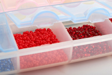 Multi-colored beads.Colorful beads on a wooden surface.It is used in finishing fashion clothes.Variety of shapes and color to make abead necklace or a string of beads toplease a woman of fashion.