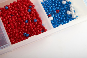 Multi-colored beads.Colorful beads on a wooden surface.It is used in finishing fashion clothes.Variety of shapes and color to make abead necklace or a string of beads toplease a woman of fashion.
