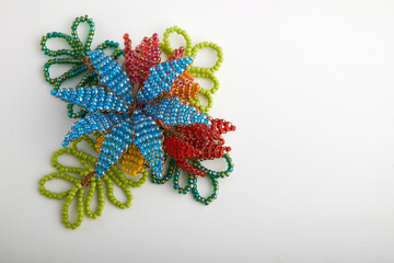 Multi-colored beads.Colorful beads on a wooden surface.It is used in finishing fashion clothes.Variety of shapes and color to make abead necklace or a string of beads toplease a woman of fashion.