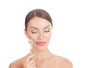 Obraz na płótnie Canvas Beauty girl using skin anti aging needles roller.