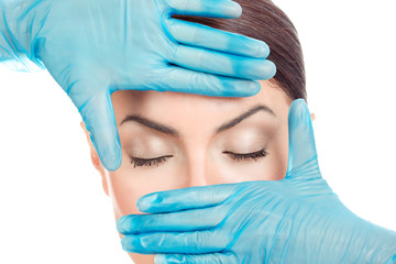 Doctor's hand in gloves around eyes of a girl.