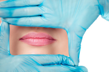 hand in gloves shaping a frame around woman lips