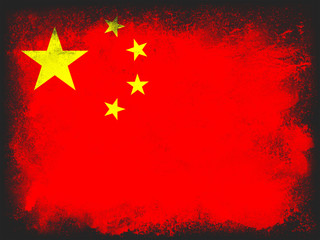 Powder paint exploding in colors of China flag isolated on white background. Abstract particles explosion of colorful dust.