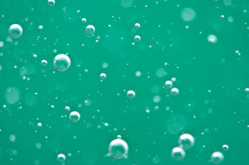 Beautiful turquoise background. Rising air bubbles in clear water. Oxygen. Macro