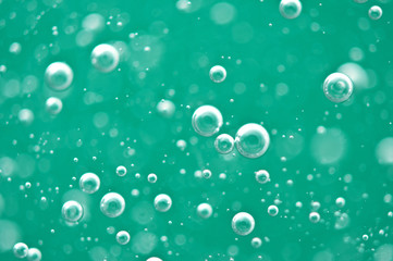 Beautiful turquoise background. Rising air bubbles in clear water. Oxygen. Macro