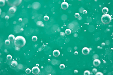 Beautiful turquoise background. Rising air bubbles in clear water. Oxygen. Macro