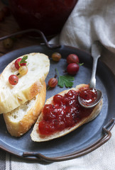 Toasts with gooseberry jam and gooseberries on a tin tray. Rustic style.