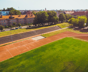 stadium with green grass and red running line