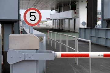 Verkehrsschild 5 km/h und geschlossene Schranke vor der Verladerampe zur Autofähre nach Norderney...