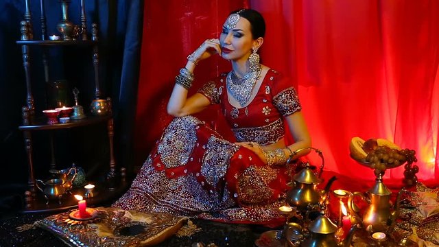 Beautiful young indian woman in traditional Sari clothing and Oriental Jewelry.