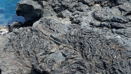 The surface of the volcanic stone. Black stone background. Rock texture. Rock pile background.