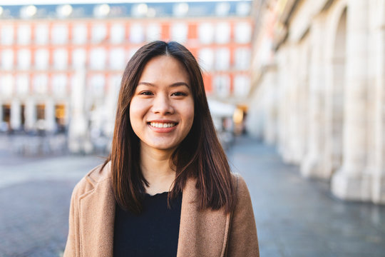 Spain, Madrid, portrait of smiling young woman at Plaza Mayor