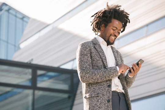 Smiling Businessman Using Cell Phone Outside Office