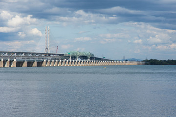 Horizontal view of the two Samuel-de-Champlain bridges over the St. Lawrence river with the south shore in the background during a beautiful summer day, Montreal, Quebec, Canada