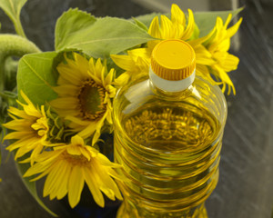  bottle with sunflower oil on a background of sunflower flowers