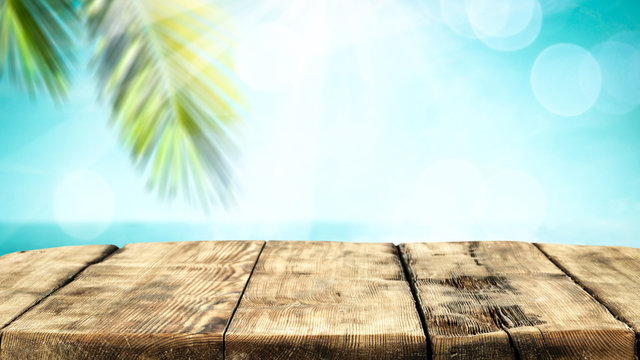 Table background with beautiful blue ocean and sandy beach view. Summer sunny day in distance. 
