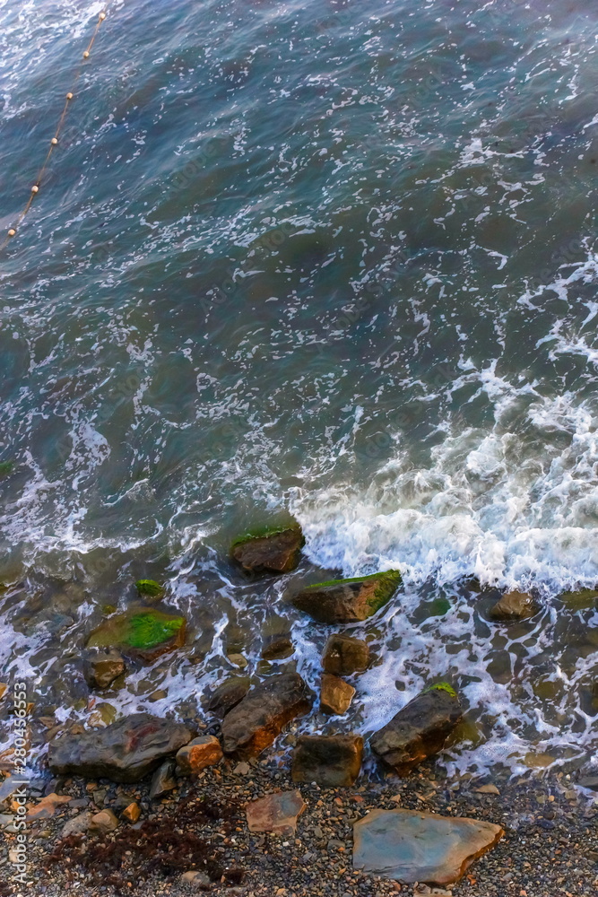 Canvas Prints sea waves sea foam. top view. stones beach