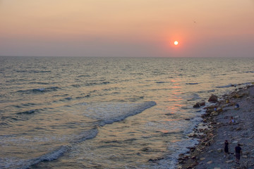 seascape sunset the sun sets the sea wave the sea foam. stones coast