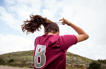 Rear view of soccer player tying her hair