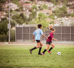 Fototapeta premium Full length of girls playing soccer on field during competition