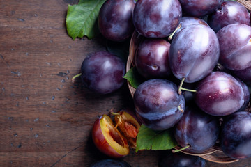 Ripe juicy plums on a old wooden table.