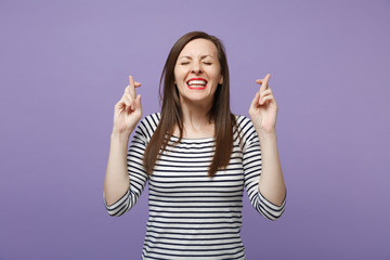 Smiling woman in striped clothes posing isolated on violet purple background. People lifestyle...