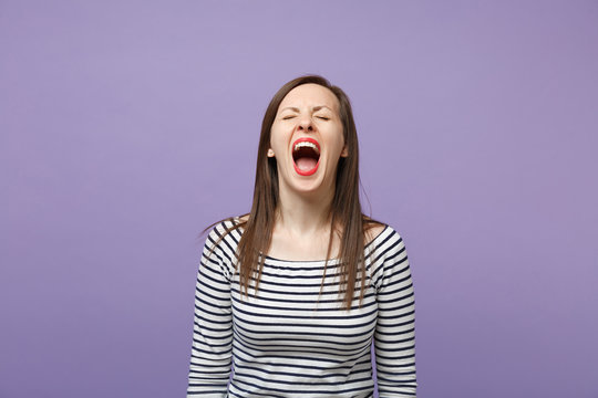 Crazy wild young brunette woman in casual striped clothes posing isolated on violet purple background studio portrait. People lifestyle concept. Mock up copy space. Keeping eyes closed, screaming. - Powered by Adobe