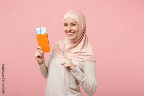 Download Smiling Young Arabian Muslim Woman In Hijab Light Clothes Posing Isolated On Pink Background People Religious Islam Lifestyle Concept Mock Up Copy Space Pointing Index Finger On Passport Ticket Wall Mural Vidi Studio