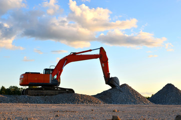 Large tracked excavator works in a gravel pit. Loading of stone and rubble for its processing at a...