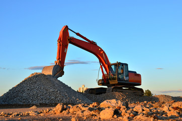 Large tracked excavator works in a gravel pit. Loading of stone and rubble for its processing at a...