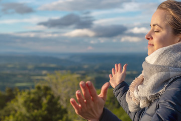 Christian worship and praise. A young woman is praying and worshiping in the evening.
