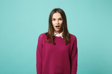 Young brunette woman girl in casual clothes posing isolated on blue green turquoise wall background studio portrait. People sincere emotions lifestyle concept. Mock up copy space. Looking camera shock