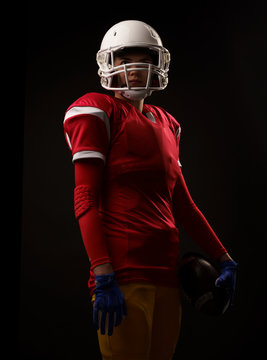 Image of woman in helmet American football player on empty black background