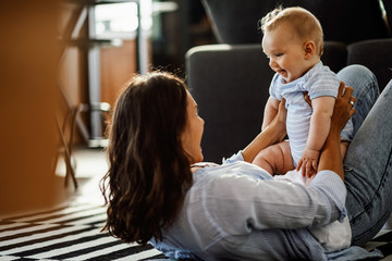 Cute baby having fun with mother at home.