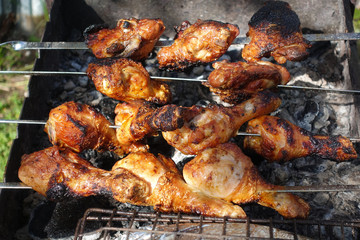 On skewers chicken skewers with vegetables are cooked on the fire.