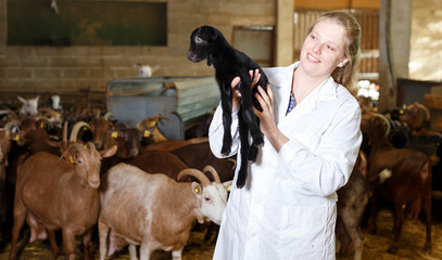 Positive farmer with goatlings on his hands