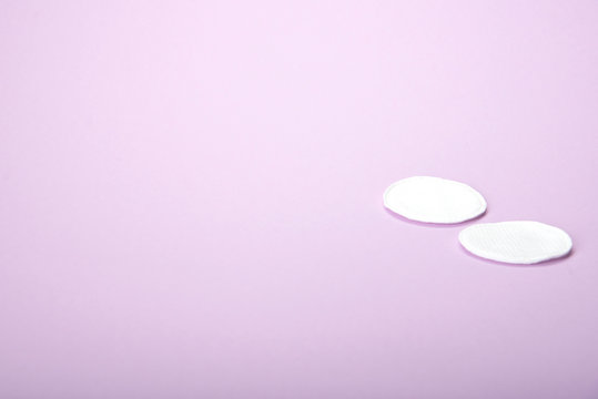 Two cosmetic cotton pads on a delicate pink background, spa, close-up © Natallia