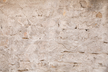 White brick wall for a background. Texture of  old, grungy brick wall with plaster. Abstract background gray. Texture with scratches and cracks.