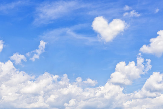 Summer sky with heart shaped cumulus cloud